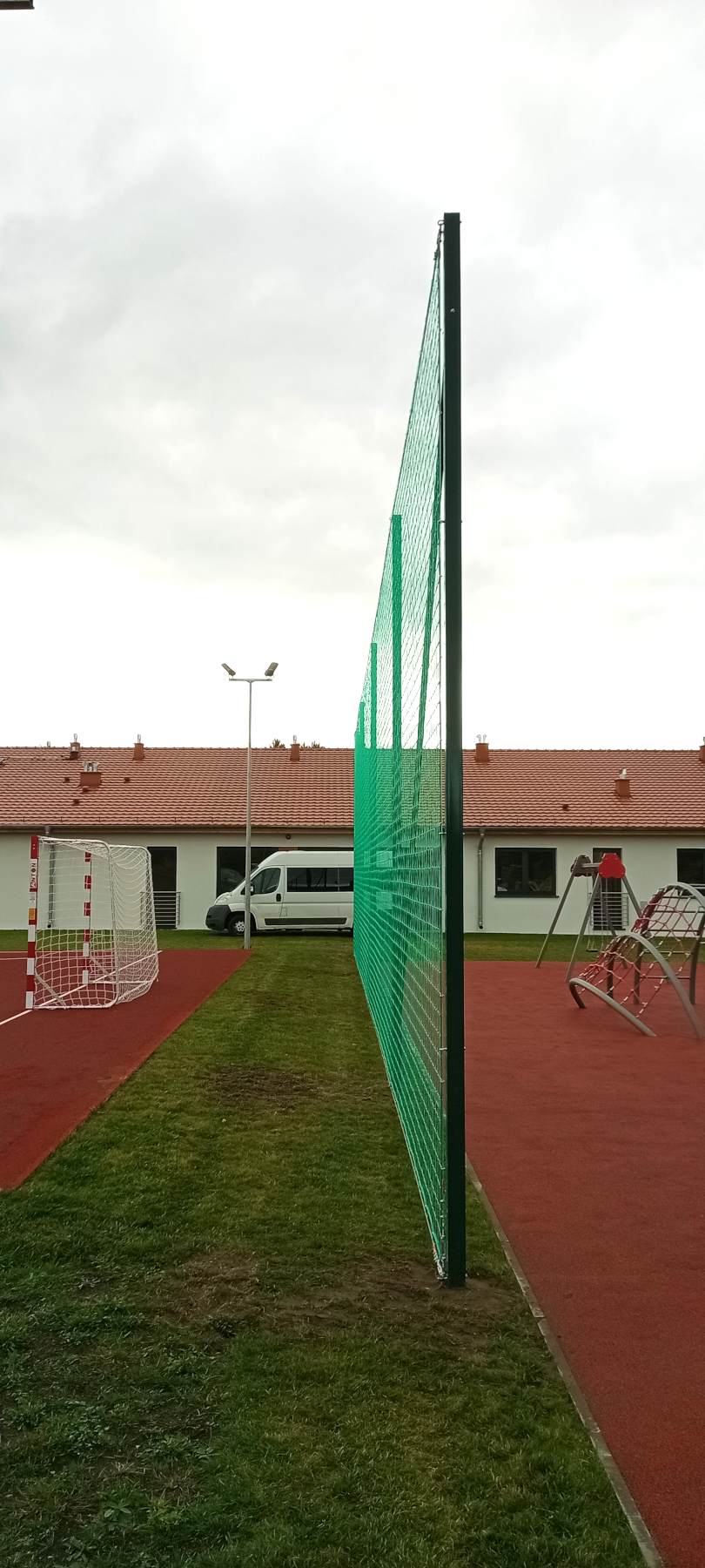 Montaż piłkochwytu o szerokości 20 metrów i wysokości 5 metrów oddzielający boisko sportowe od placu zabaw.