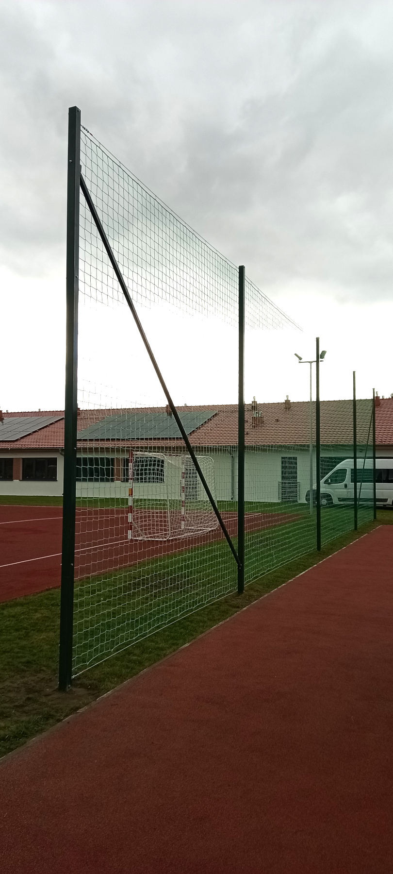 Montaż piłkochwytu o szerokości 20 metrów i wysokości 5 metrów oddzielający boisko sportowe od placu zabaw.