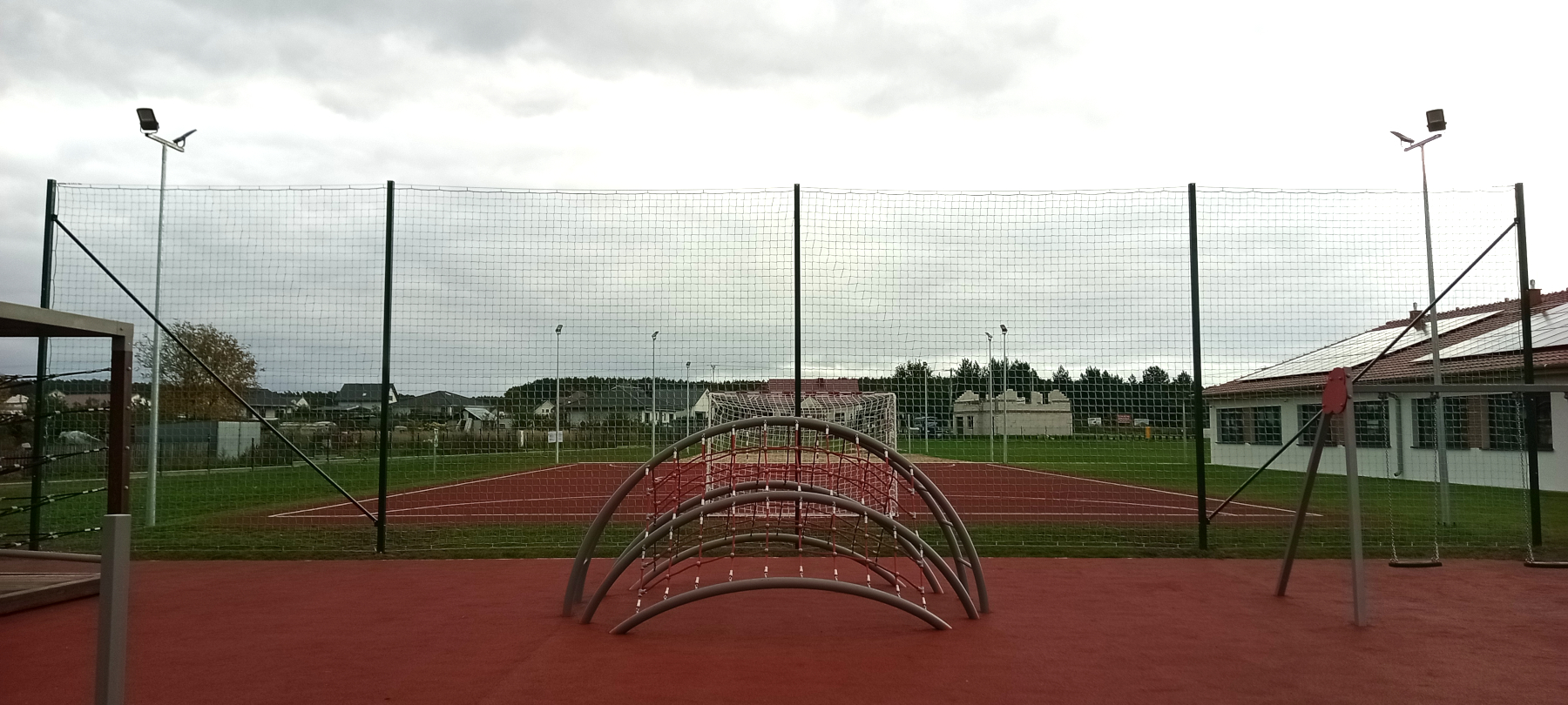 Montaż piłkochwytu o szerokości 20 metrów i wysokości 5 metrów oddzielający boisko sportowe od placu zabaw.